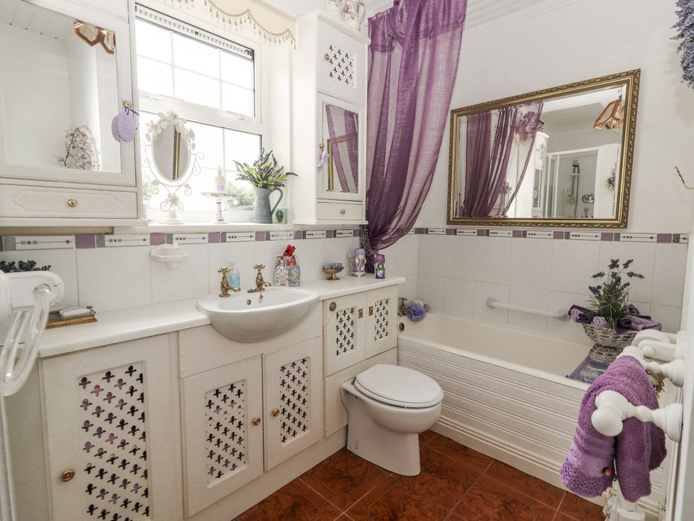A bathroom with a sink, toilet, and bathtub at White Heather Cottage in Killalou