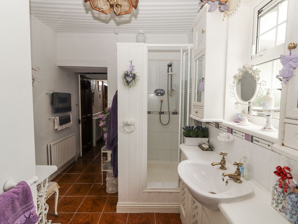 A bathroom with a shower and sink at White Heather Cottage in Killalou
