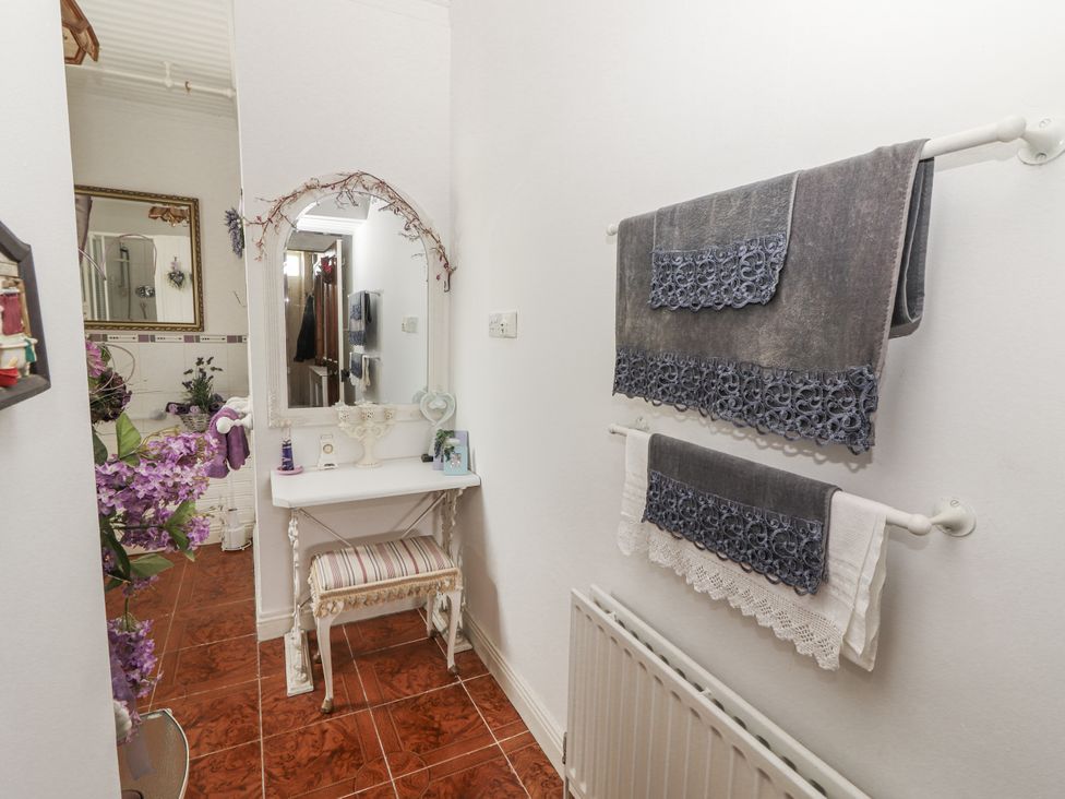 A bathroom featuring towels and a mirror at White Heather Cottage in Killalou