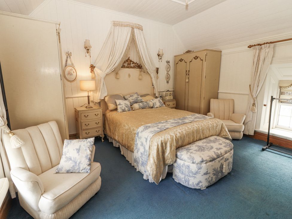 A bedroom with a bed and furniture at White Heather Cottage in Killalou