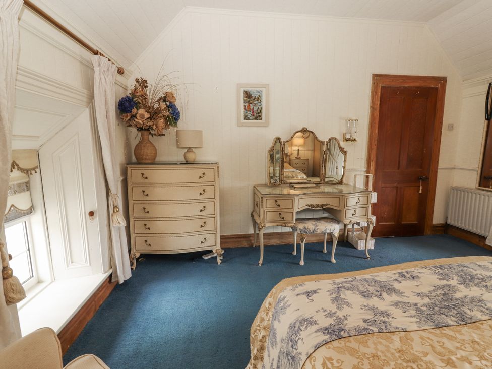 A bedroom with a dresser and mirror at White Heather Cottage in Killalou