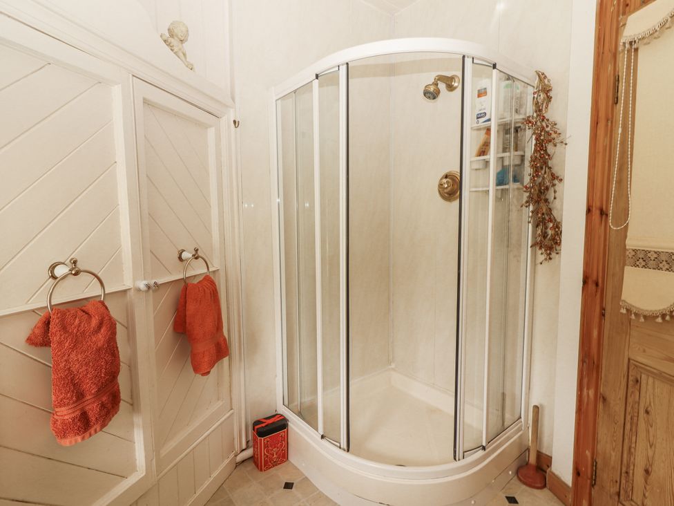 A bathroom featuring a shower and towels at White Heather Cottage in Killalou