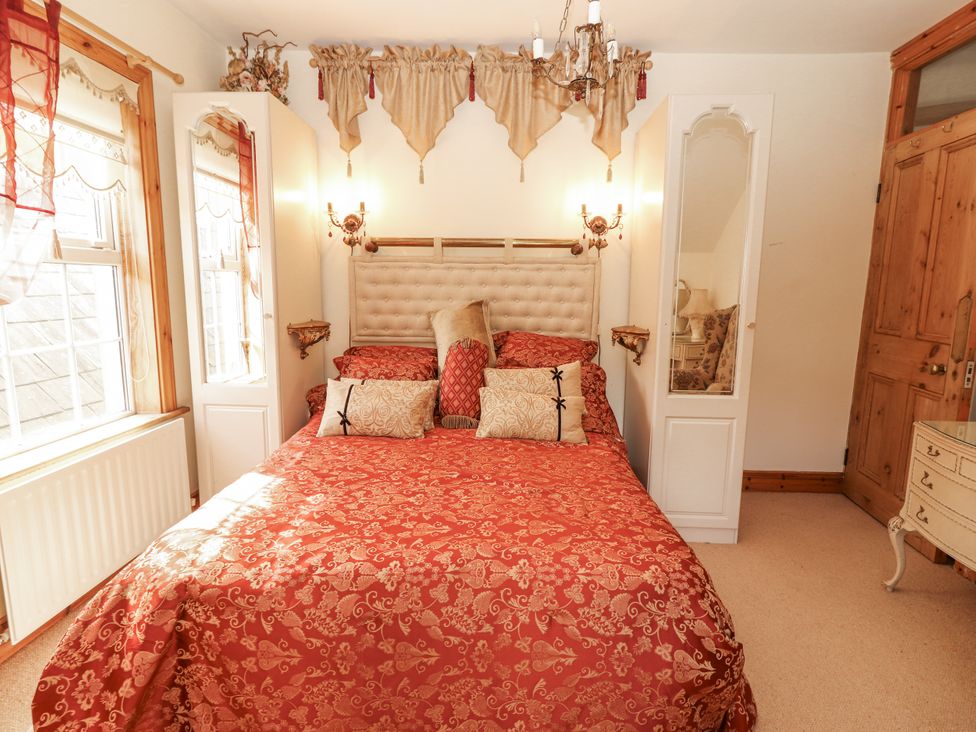 A bedroom with a bed and pillows at White Heather Cottage in Killalou