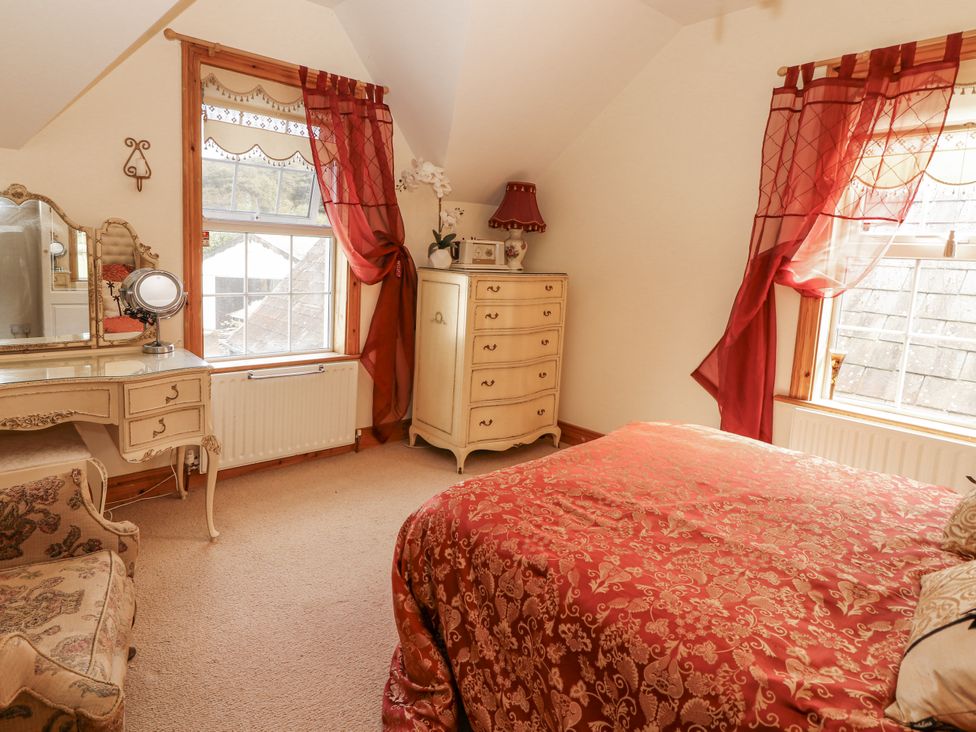 A bedroom with a bed and a desk at White Heather Cottage in Killalou