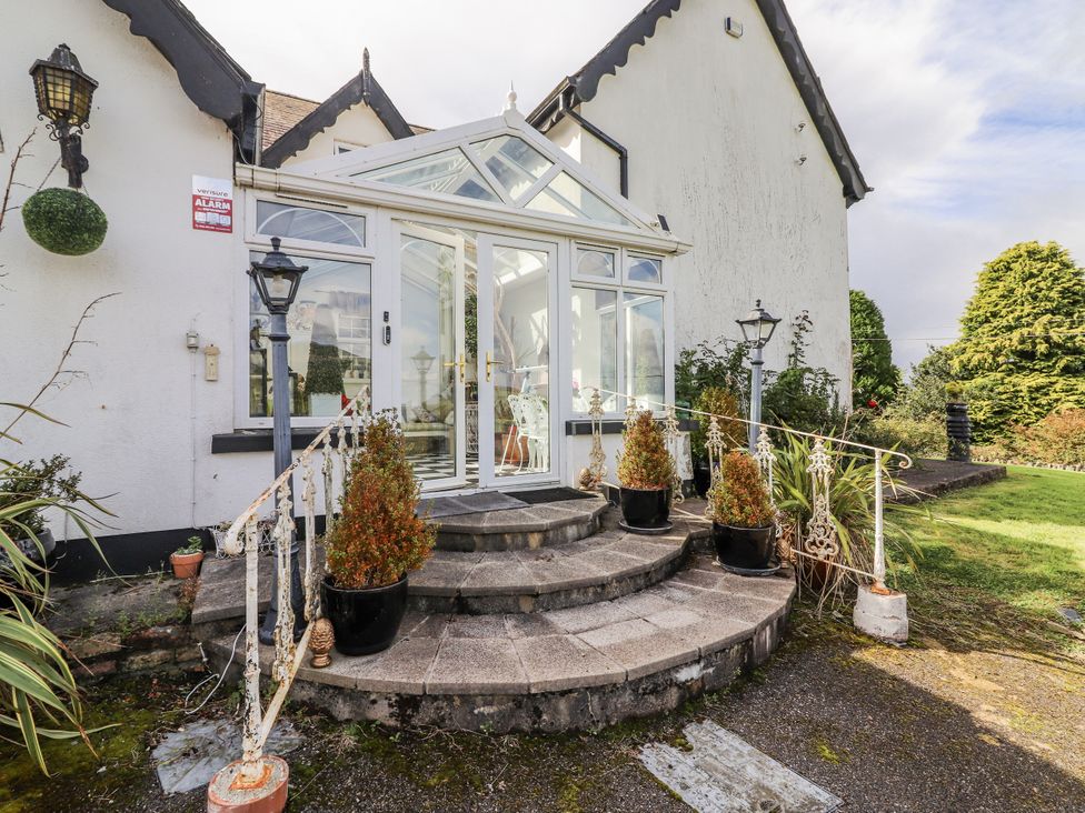 An outdoor area with a glass conservatory and stairs at White Heather Cottage in Killalou