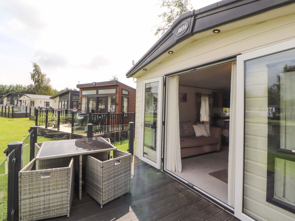 An outdoor area with a deck and seating at 22 Yealand in Carnforth