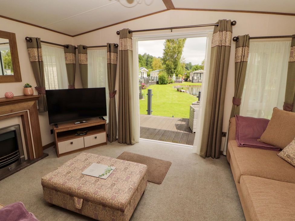 A living room with a television and sofa at 22 Yealand in Carnforth