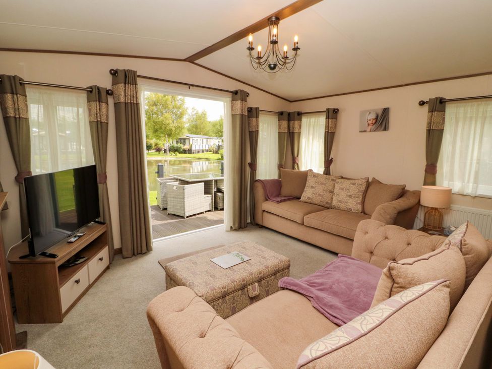 A living room with a sofa and television at 22 Yealand in Carnforth