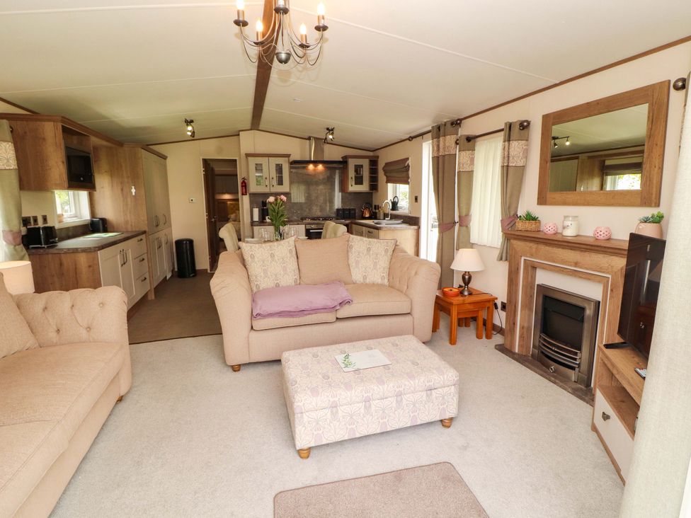 A living room with a sofa and fireplace at 22 Yealand in Carnforth