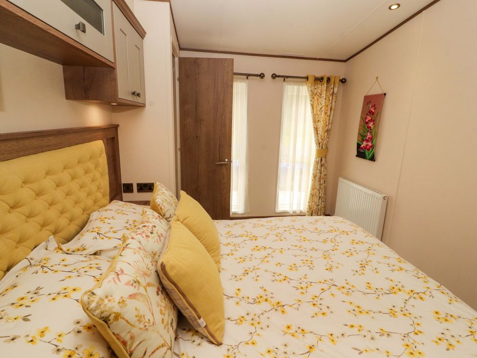 A bedroom with a bed and curtains at 22 Yealand Carnforth