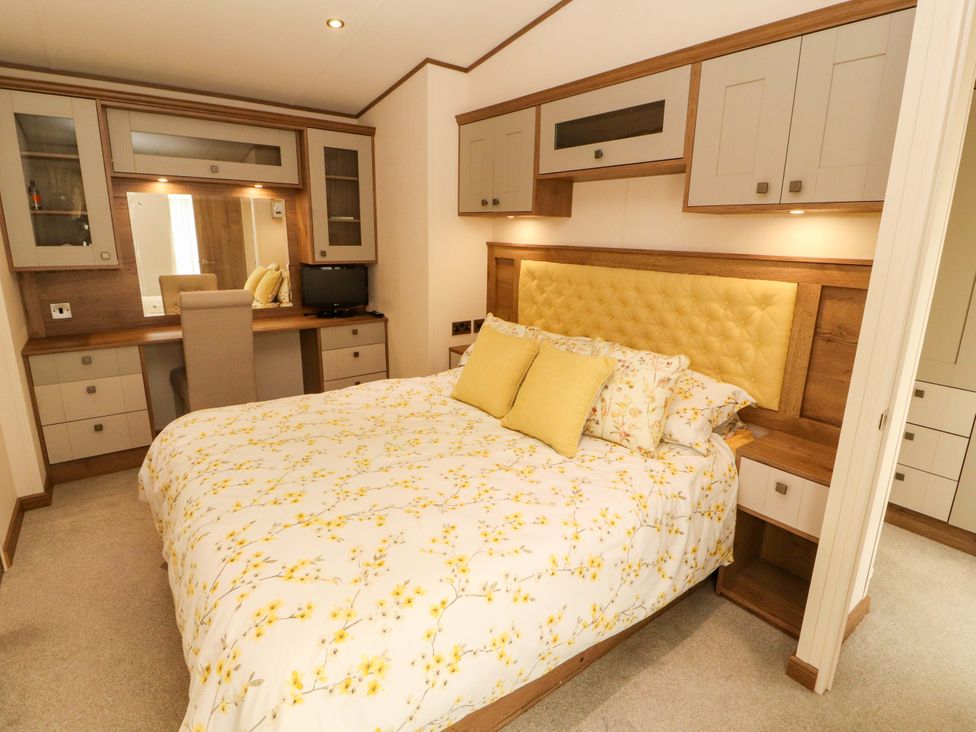 A bedroom with a bed and a dressing table at 22 Yealand in Carnforth