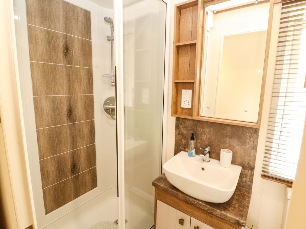 A bathroom with a shower and sink at 22 Yealand in Carnforth