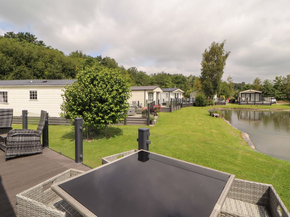 An outdoor view of holiday homes by a lake at 22 Yealand in Carnforth