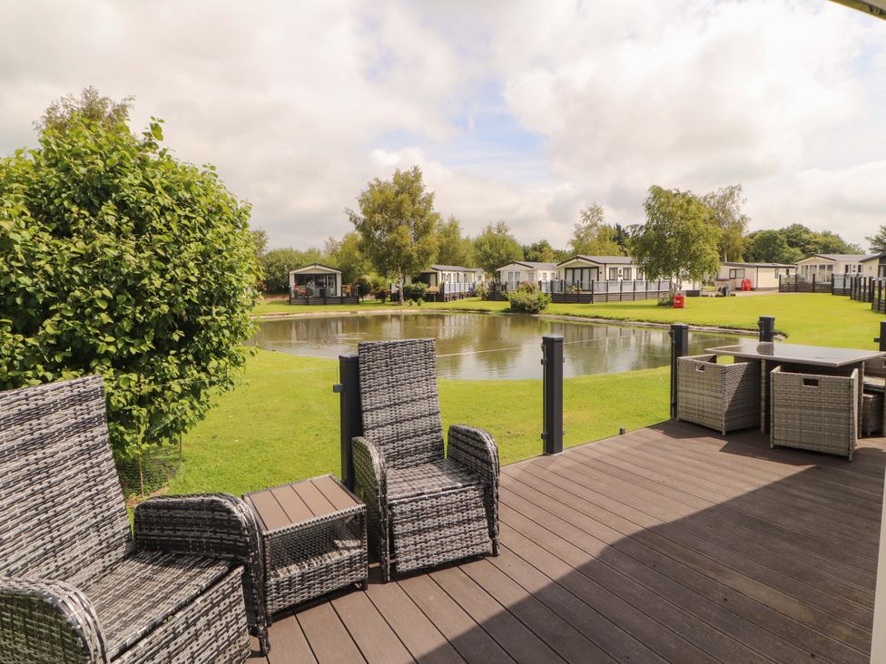 An outdoor seating area overlooking a pond at 22 Yealand in Carnforth