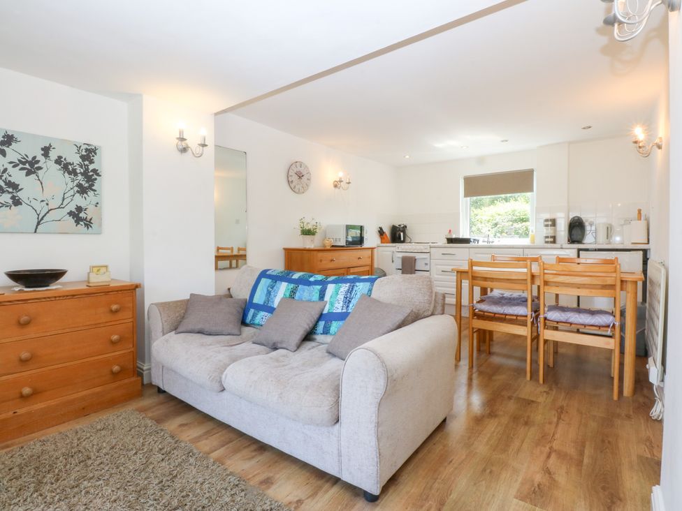 A living room with a sofa and dining table at Hafan Bach in Abersoch