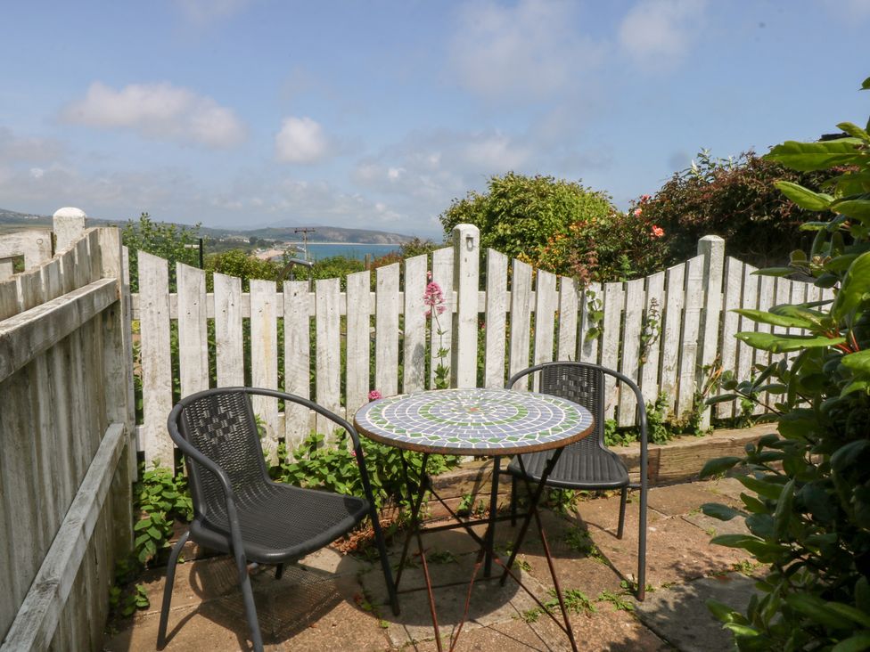 A garden with a table and chairs at Hafan Bach in Abersoch