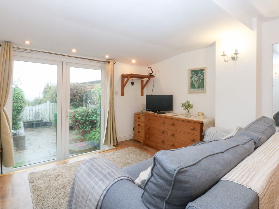 A snug room with a sofa and television at Hafan Bach in Bwlchtocyn near Abersoch