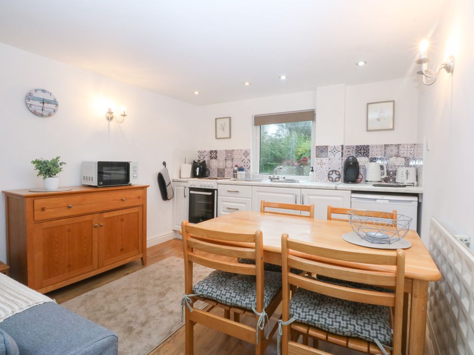 A kitchen with dining table and chairs at Hafan Bach Bwlchtocyn near Abersoch