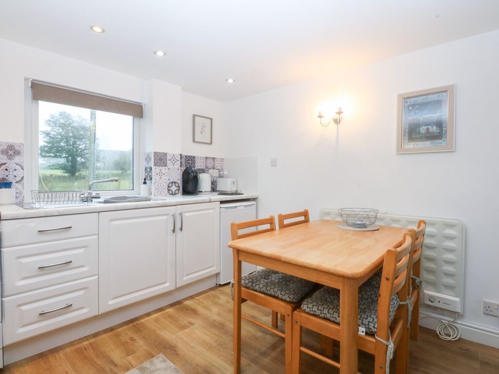 A kitchen with a table and chairs at Hafan Bach in Bwlchtocyn near Abersoch