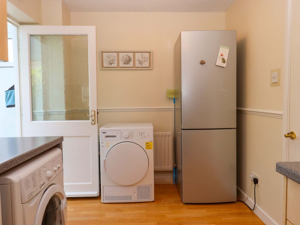 A kitchen with a washing machine and a refrigerator at Hedgehogs in Barnstaple