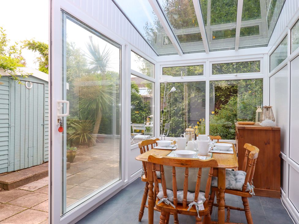 A conservatory with a table and chairs at Hedgehogs in Barnstaple