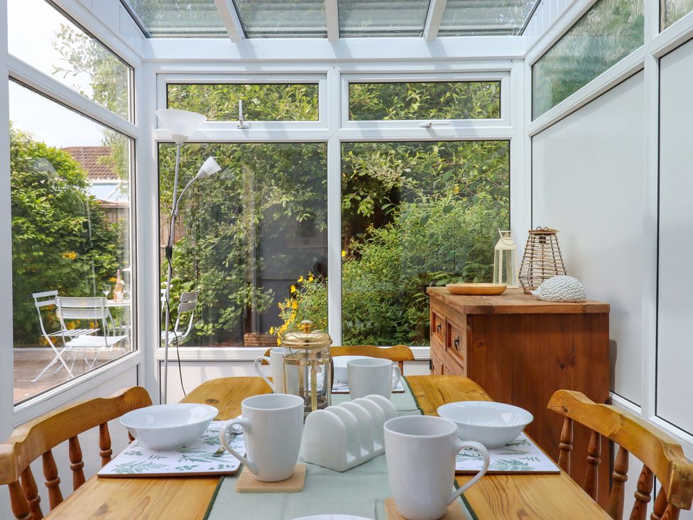 A conservatory with a dining table and chairs at Hedgehogs in Barnstaple
