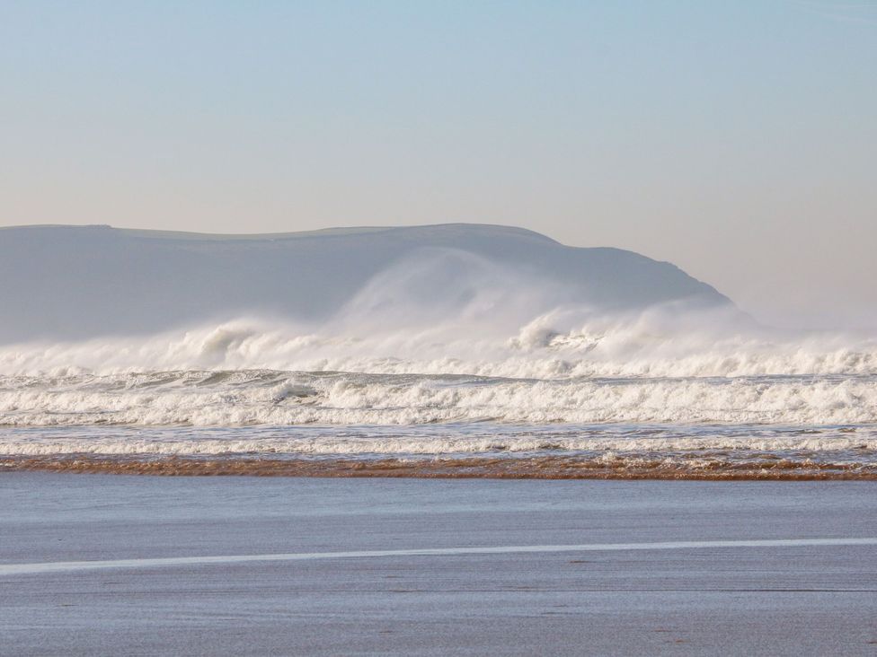 A beach with waves and distant hills at Hedgehogs Barnstaple
