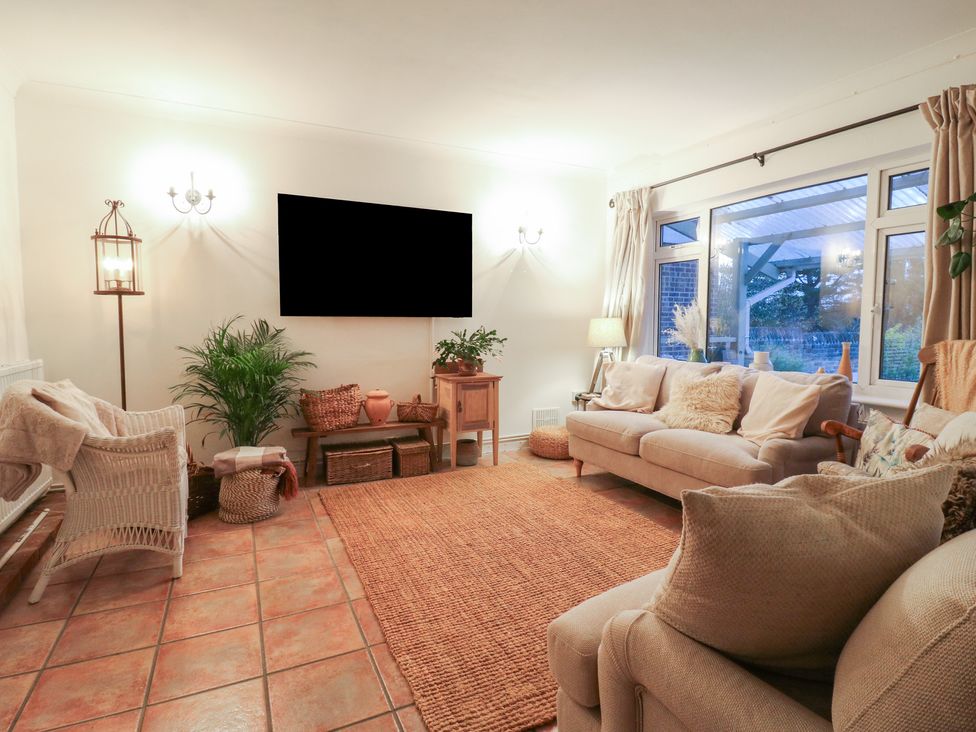 A living room with a sofa and television at Berkley Cottage in Colchester