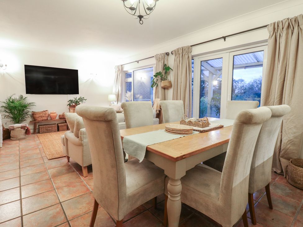A dining room with a table and chairs at Berkley Cottage in Colchester
