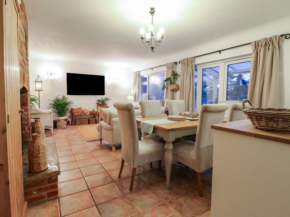 A dining room with a table and chairs at Berkley Cottage in Colchester