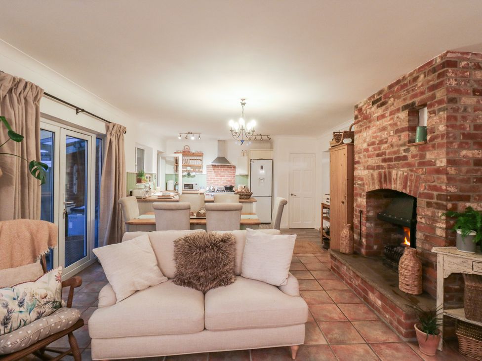 A living room with a sofa and dining area at Berkley Cottage in Colchester