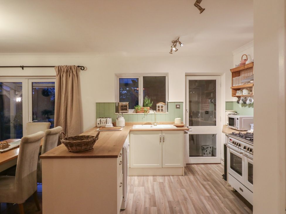 A kitchen with cabinets and a sink at Berkley Cottage in Colchester