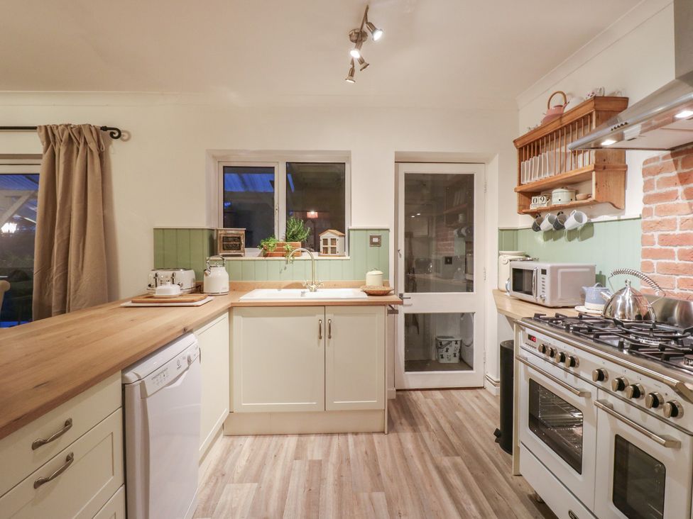 A kitchen with a sink and appliances at Berkley Cottage in Colchester