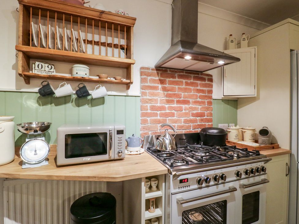 A kitchen with stove and microwave at Berkley Cottage in Colchester