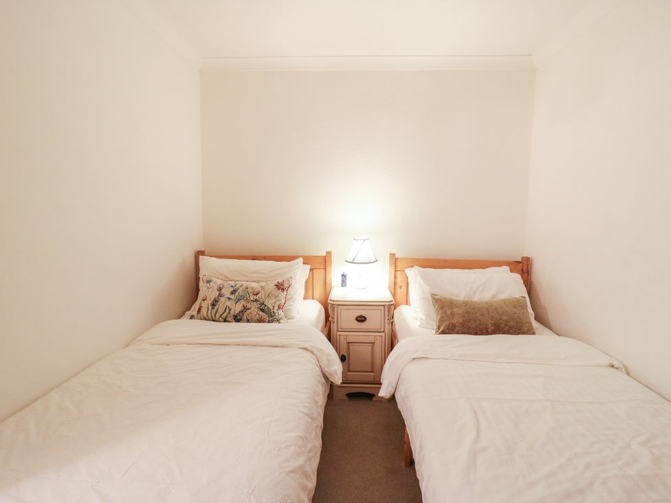 A bedroom with two single beds and a nightstand at Berkley Cottage in Colchester