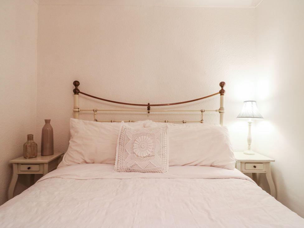 A bedroom with a bed and bedside table at Berkley Cottage in Colchester