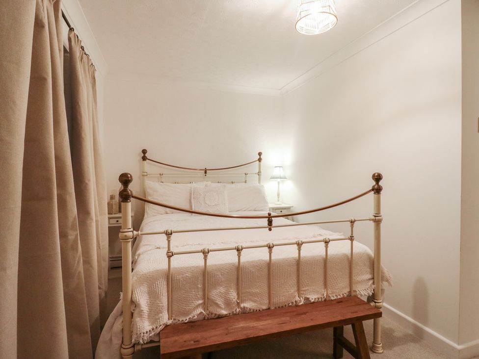 A bedroom with a bed and lamp at Berkley Cottage in Colchester