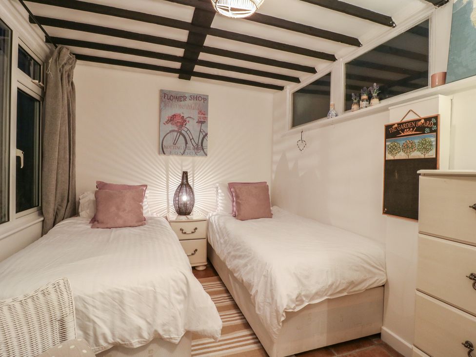 A bedroom with two beds and a lamp at Berkley Cottage in Colchester