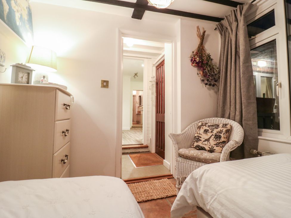 A bedroom with a dresser and chair at Berkley Cottage in Colchester