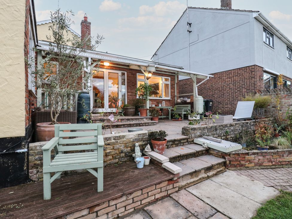 A garden with patio steps and potted plants at Berkley Cottage in Colchester