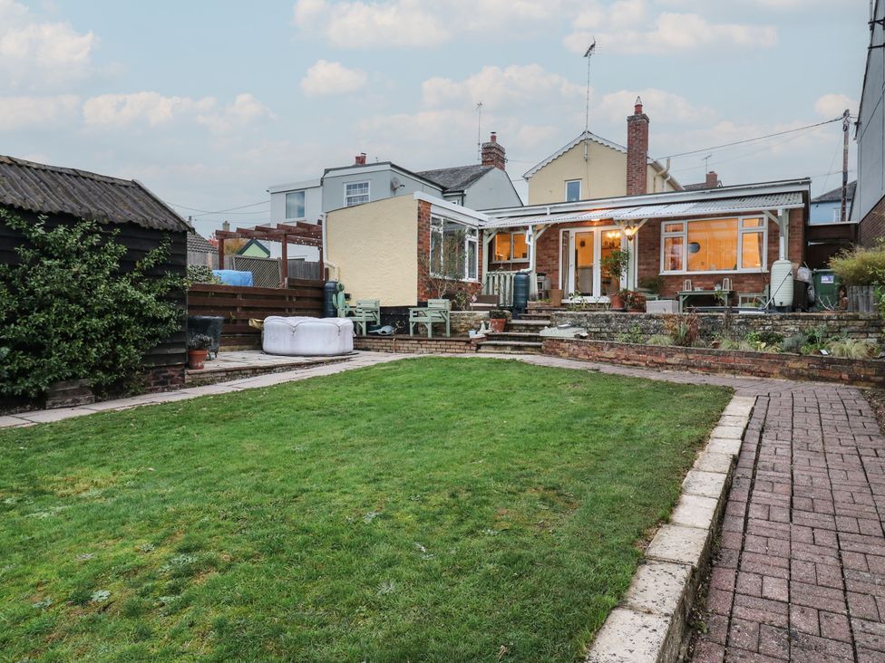 A garden with a paved pathway and outdoor furniture at Berkley Cottage in Colchester