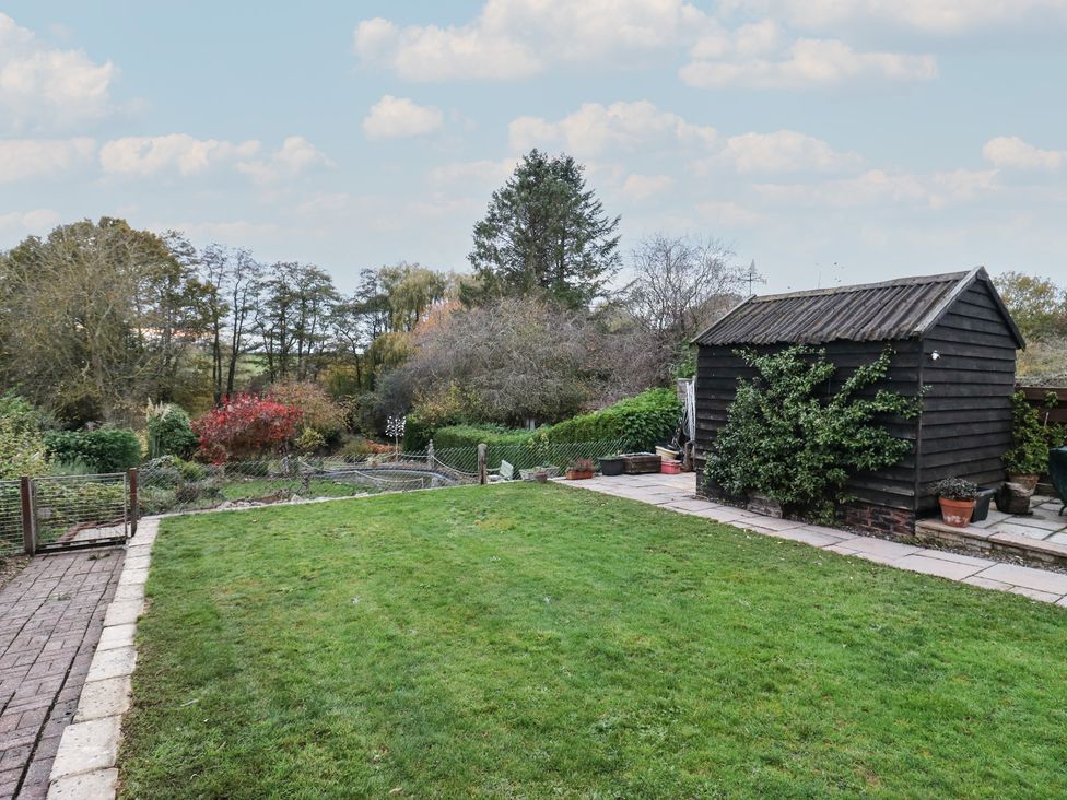 A garden with a shed and pathway at Berkley Cottage in Colchester