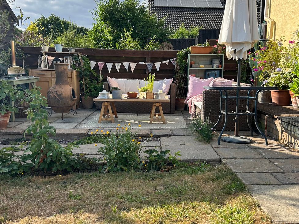 A garden setup with chairs and cushions at Berkley Cottage in Coggeshall
