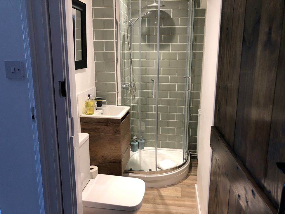 A bathroom with a shower, toilet, and sink at Berkley Cottage in Coggeshall