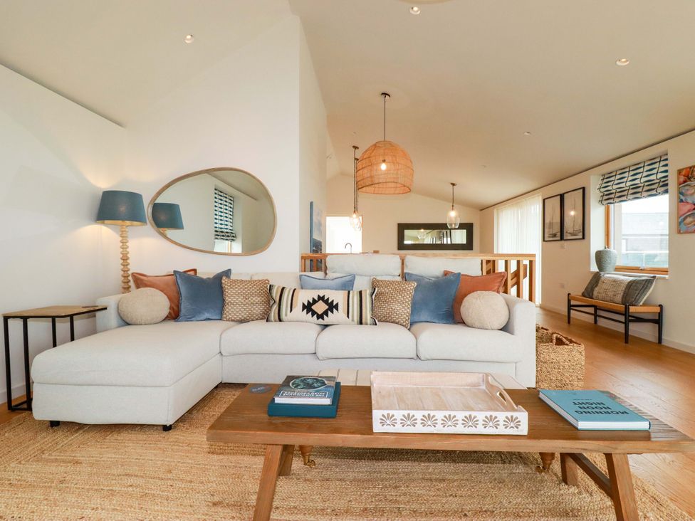 A living room with a sectional sofa and coffee table at 8 Karn Havos in St. Eval near Mawgan Porth