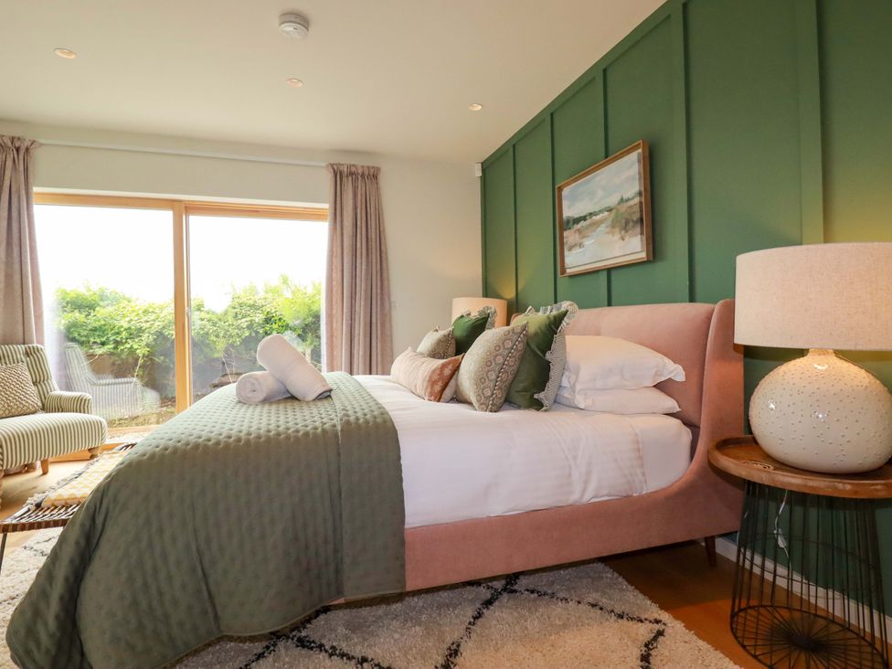A bedroom with a bed and a chair at 8 Karn Havos St. Eval near Mawgan Porth