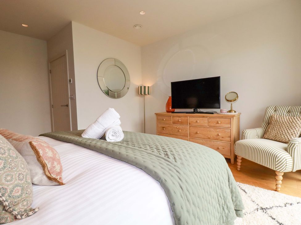 A bedroom with a bed, dresser, and television at 8 Karn Havos St. Eval near Mawgan Porth