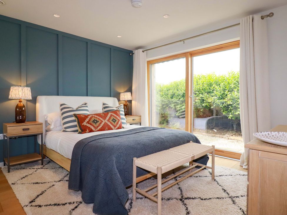 A bedroom with a bed and nightstands at 8 Karn Havos in St. Eval near Mawgan Porth