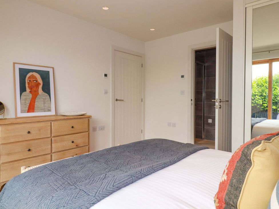 A bedroom with a bed and artwork on the wall at 8 Karn Havos in St. Eval near Mawgan Porth