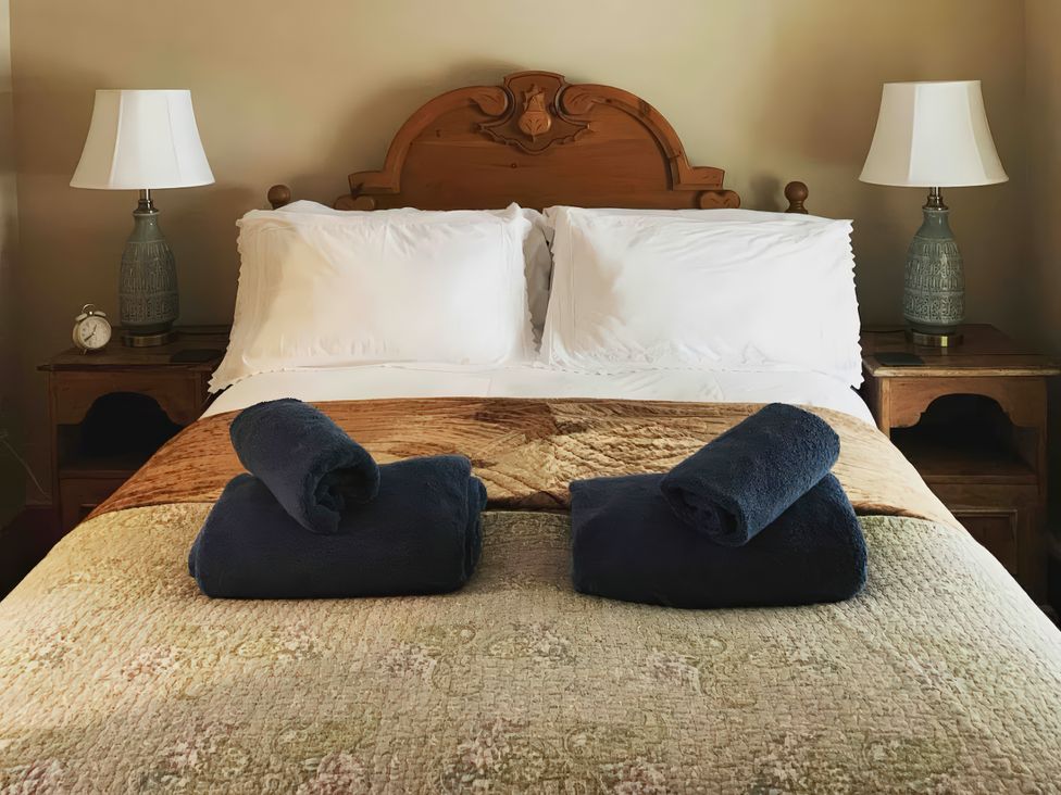 A bedroom with a bed, pillows and towels at Copper Miners Cottage, Beddgelert, Eryri (snowdonia)